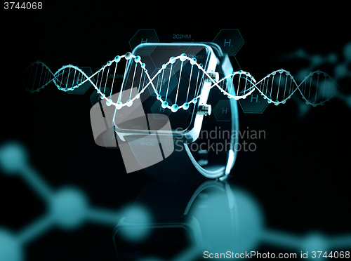 Image of close up of black smart watch over dna molecules