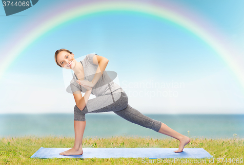 Image of woman making yoga low angle lunge pose on mat