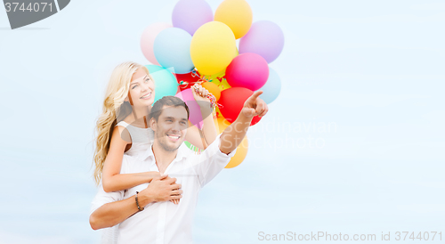 Image of couple with colorful balloons at sea side