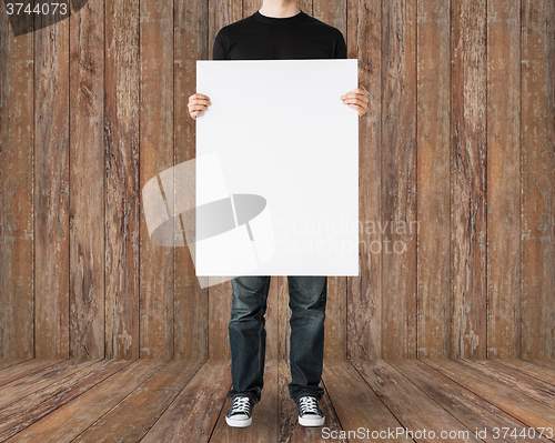 Image of close up of man holding big blank white board