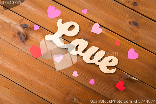 Image of close up of word love with red paper hearts