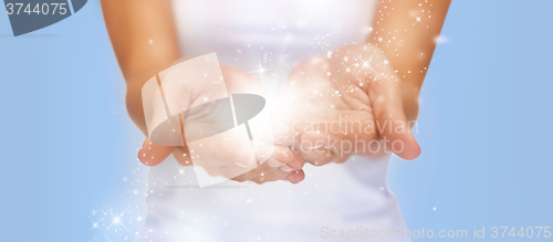 Image of magic twinkles or fairy dust on female hands