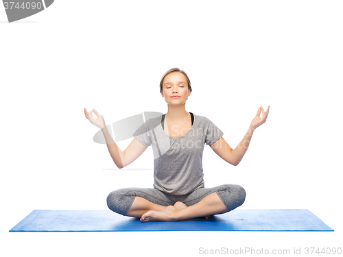 Image of woman making yoga meditation in lotus pose on mat