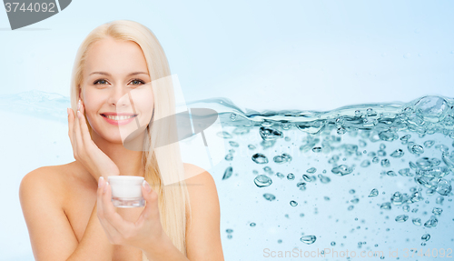 Image of woman applying moisturizing cream to her face skin