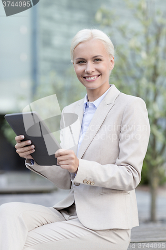 Image of smiling businesswoman with tablet pc outdoors