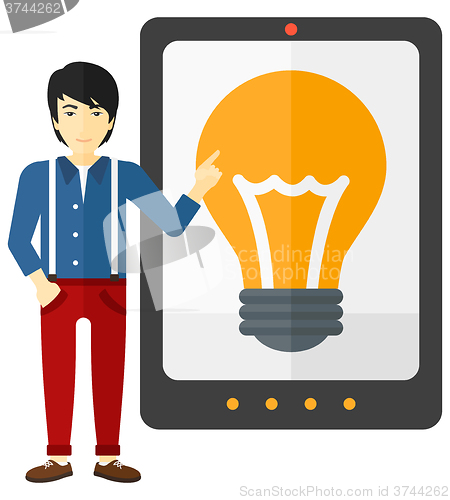 Image of Man pointing at tablet computer with light bulb on screen.