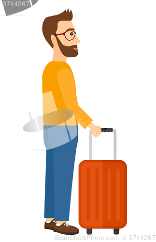 Image of Man standing with suitcase.