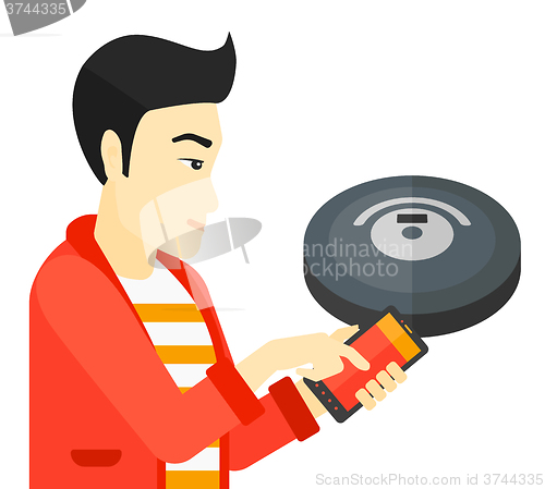 Image of Man with robot vacuum cleaner.