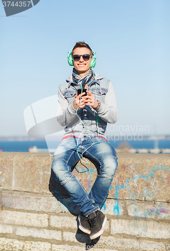 Image of happy young man with tablet pc and headphones