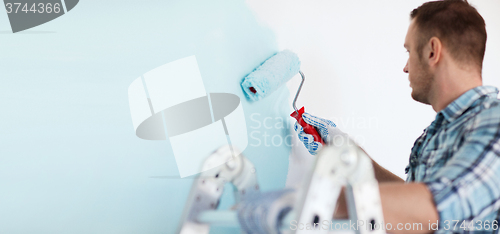 Image of close up of male in gloves holding painting roller