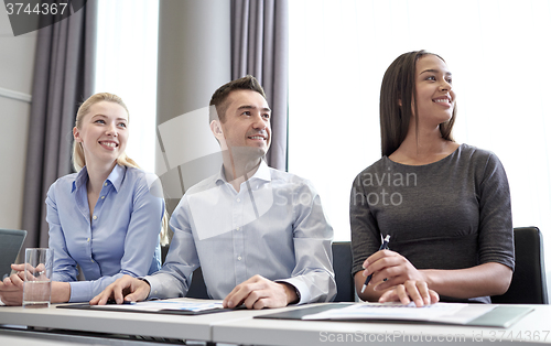 Image of smiling business people meeting in office