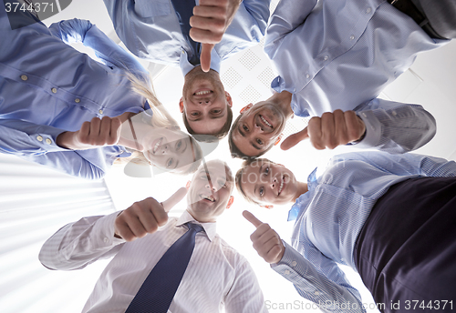 Image of smiling group of businesspeople standing in circle