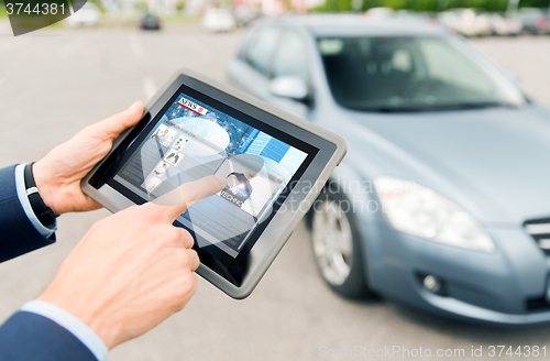 Image of close up of hands with news on tablet pc and car