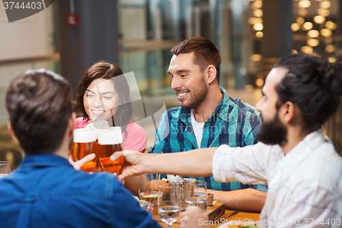 Image of friends dining and drinking beer at restaurant