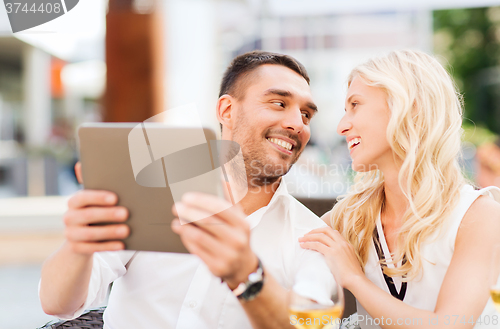 Image of happy couple with tablet pc at restaurant lounge