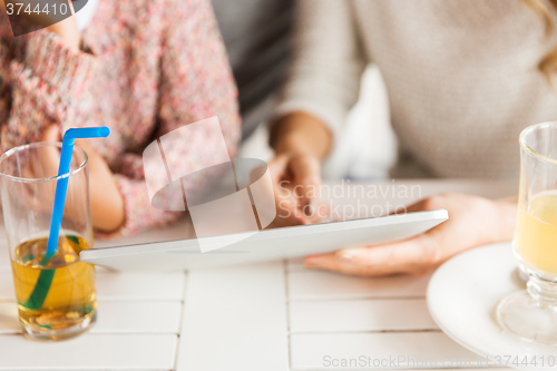 Image of close up of family with tablet pc at restaurant