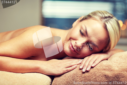 Image of young woman lying on massage table in spa