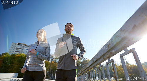 Image of happy couple running outdoors