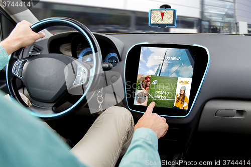 Image of close up of man driving car with news application