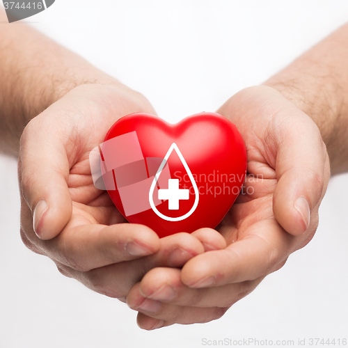Image of male hands holding red heart with donor sign