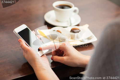 Image of close up of woman with smartphone and dessert