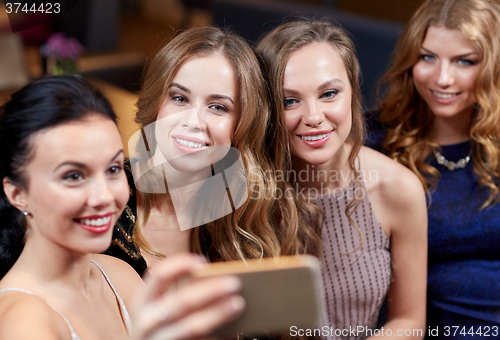 Image of women with smartphone taking selfie at night club