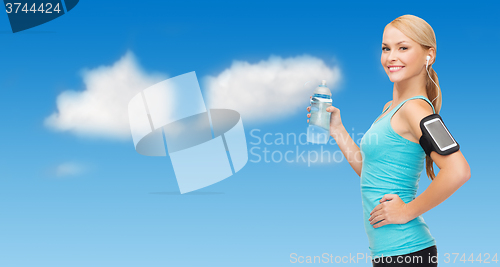 Image of sporty woman running with smartphone and earphones
