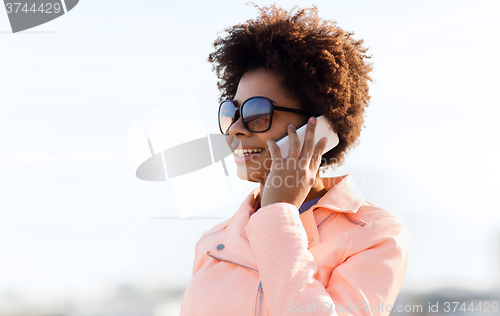 Image of smiling african american woman with smartphone