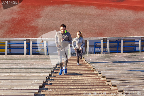 Image of happy couple running upstairs on stadium