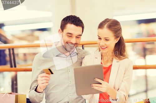 Image of couple with tablet pc and shopping bags in mall