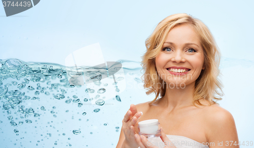 Image of happy middle aged woman with moisturizing cream