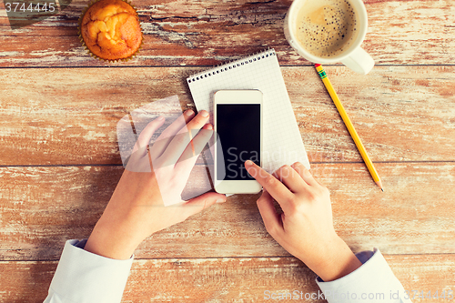 Image of close up of hands with smartphone and coffee cup