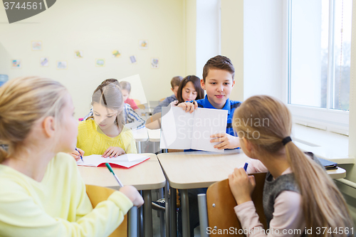 Image of group of school kids writing test in classroom