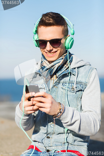 Image of happy young man in headphones with smartphone