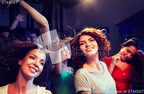 Image of smiling friends dancing in club