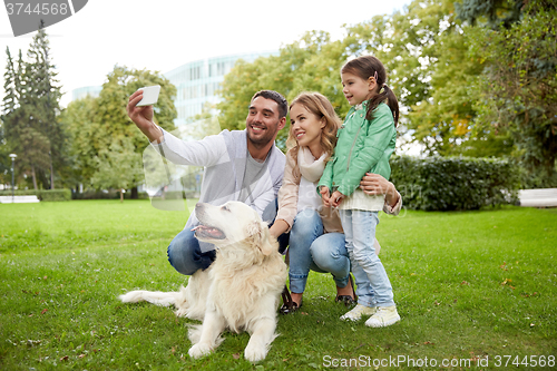 Image of happy family with dog taking selfie by smartphone