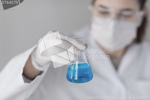 Image of close up of woman with flask making test in lab