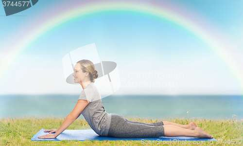 Image of woman making yoga in dog pose on mat