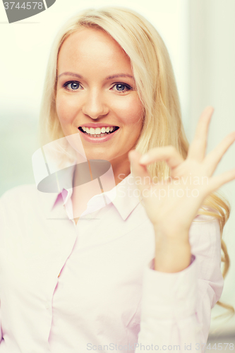 Image of smiling businesswoman or secretary in office