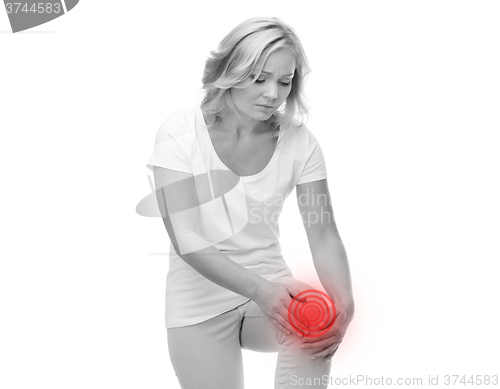 Image of unhappy woman suffering from pain in leg