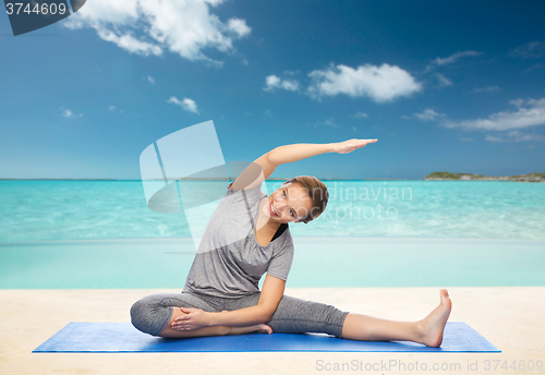 Image of happy woman making yoga and stretching on mat