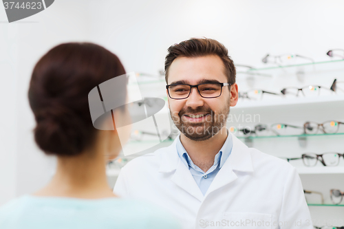 Image of woman and optician in glasses at optics store