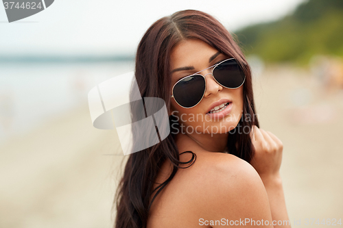 Image of young woman with sunglasses on beach