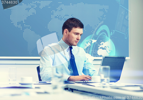 Image of businessman with laptop working in office