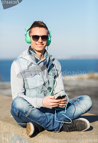Image of happy young man in headphones with smartphone