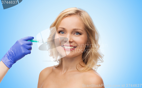 Image of happy woman face and beautician hand with syringe