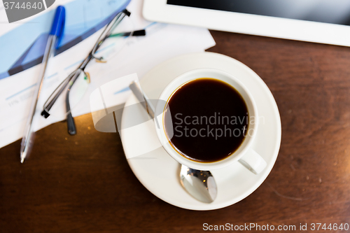 Image of close up of coffee, charts and tablet pc on table