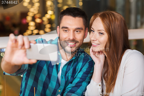 Image of couple taking selfie by smartphone at restaurant