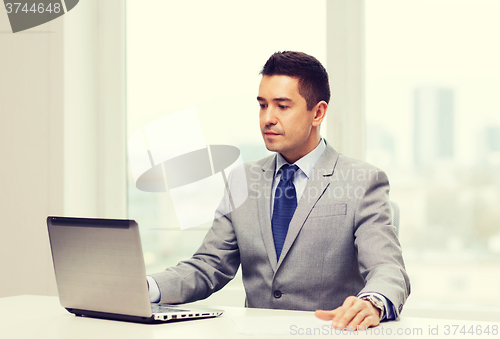 Image of businessman working with laptop in office