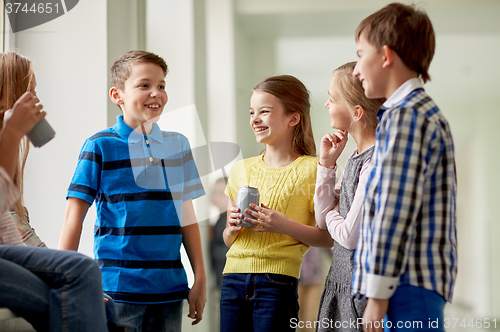 Image of group of school kids with soda cans in corridor